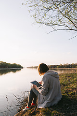 Image showing girl working with tablet at the river