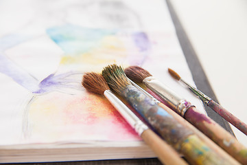Image showing paint brushes lying on painted background