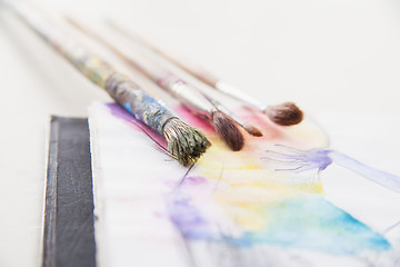 Image showing paint brushes lying on painted background