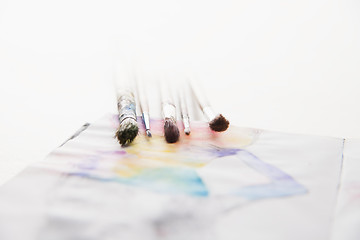 Image showing paint brushes lying on painted background