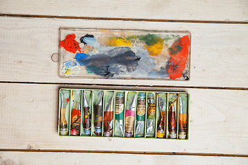 Image showing Used paint tubes on a wooden background