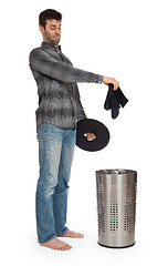 Image showing Young man putting a dirty socks in a laundry basket