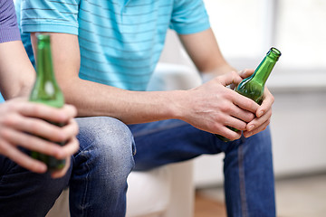 Image showing close up of male friends drinking beer at home