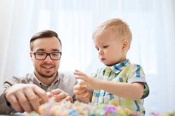 Image showing father and son playing with ball clay at home