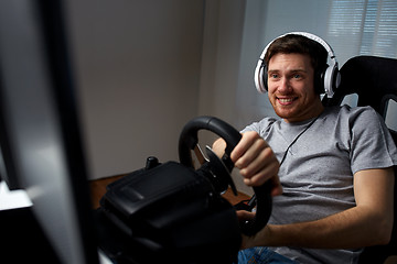 Image showing man playing car racing video game at home