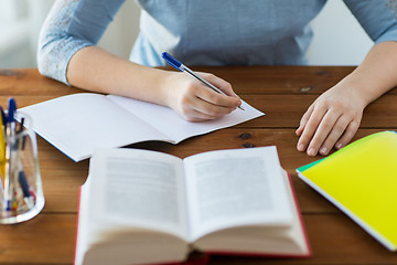 Image showing close up of student with book and notebook at home