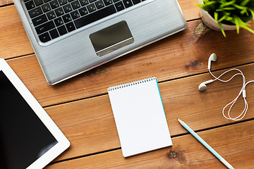 Image showing close up of notebook, laptop and tablet pc on wood