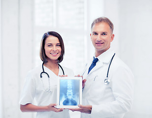 Image showing two doctors showing x-ray on tablet pc