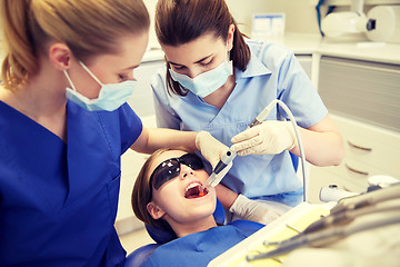 Image showing female dentists treating patient girl teeth