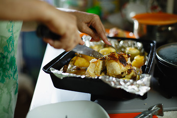 Image showing woman cut a roasted chicken