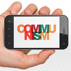Image showing Political concept: Hand Holding Smartphone with Communism on  display