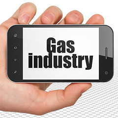 Image showing Manufacuring concept: Hand Holding Smartphone with Gas Industry on display