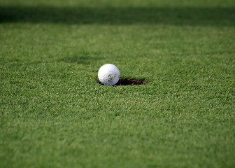 Image showing Golfball falling in the hole