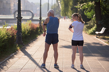 Image showing jogging couple planning running route  and setting music