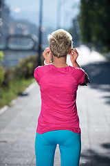 Image showing jogging woman setting phone before jogging