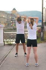 Image showing couple warming up before jogging