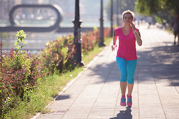 Image showing sporty woman running  on sidewalk