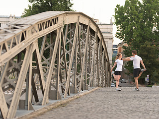 Image showing couple warming up and stretching before jogging