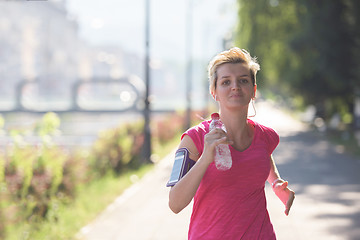 Image showing sporty woman running  on sidewalk