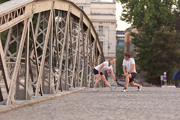 Image showing couple warming up and stretching before jogging