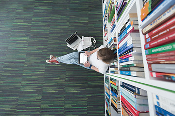 Image showing female student study in library, using tablet and searching for 