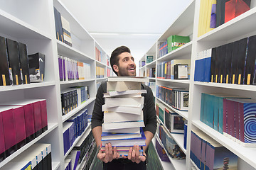 Image showing Student holding lot of books in school library