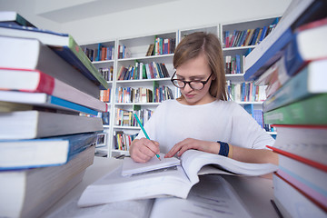 Image showing female student study in library, using tablet and searching for 