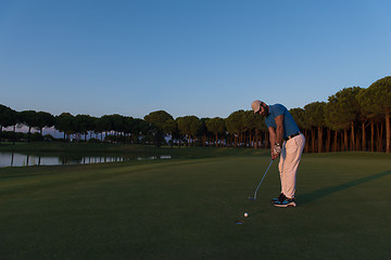 Image showing golfer  hitting shot at golf course