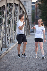 Image showing couple warming up and stretching before jogging