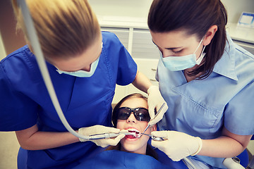 Image showing female dentists treating patient girl teeth