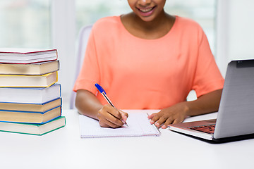 Image showing close up of woman with laptop and books at home