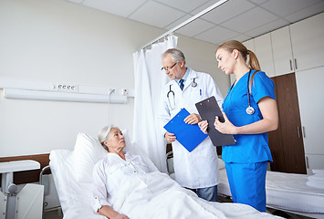 Image showing doctor and nurse visiting senior woman at hospital