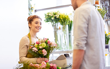 Image showing smiling florist woman and man at flower shop