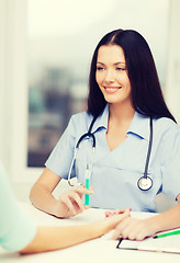 Image showing smiling female doctor or nurse with syringe