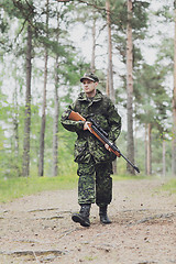 Image showing young soldier or hunter with gun in forest