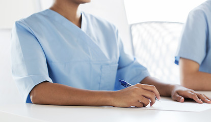 Image showing close up of doctor taking notes at hospital