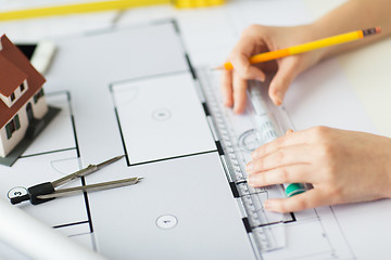 Image showing close up of hands with compass measuring blueprint