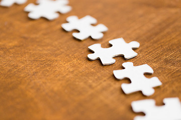 Image showing close up of puzzle pieces on wooden surface