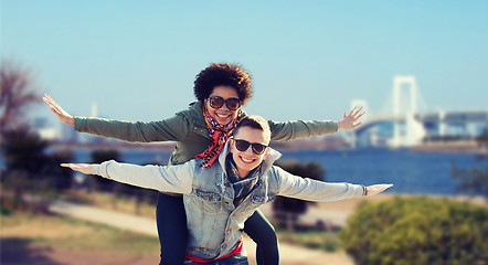 Image showing happy teenage couple in shades having fun outdoors