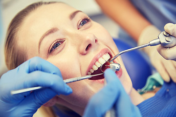 Image showing close up of dentist treating female patient teeth