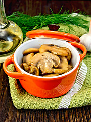 Image showing Champignons fried in roaster with oil on board