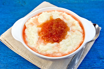 Image showing Rice porridge with jam in bowl on blue board