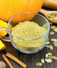 Image showing Flour pumpkin in glass cup with cinnamon on board