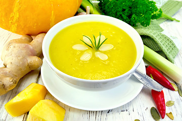 Image showing Soup-puree pumpkin with rosemary in bowl on board