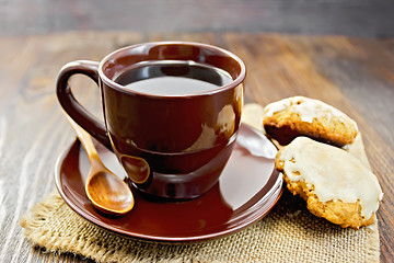 Image showing Coffee in brown cup with cookies on board