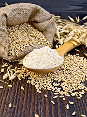 Image showing Flour oat in wooden spoon with bag on board