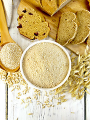 Image showing Flour oat in white bowl with bran in spoon on board top