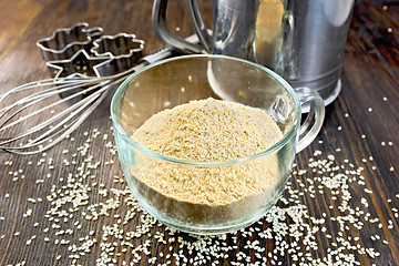 Image showing Flour sesame in cup with sieve and mixer on board