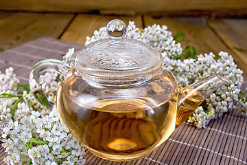 Image showing Tea with yarrow in glass teapot on bamboo