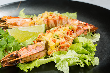 Image showing perfect dish with shrimps on a black plate. seafood